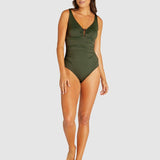 Model wearing full-length Baku Rococco Ring Front Swimsuit in olive, designed to flatter curves with underwire support, from The Foundation.