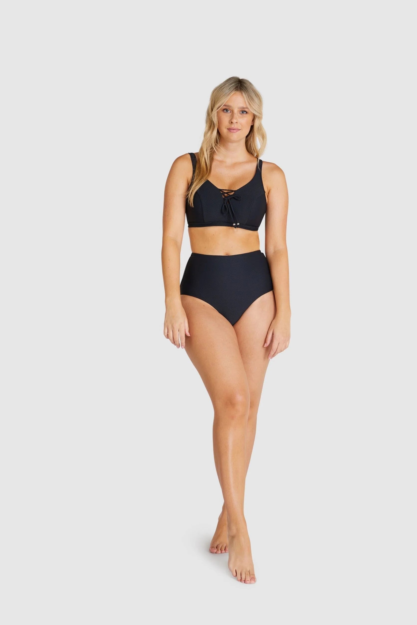 Model wearing Baku Rococco EFG Cup Bra Nero, a black supportive bra with lace details, wide straps, and full coverage fit, available at The Foundation.