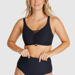 Front-facing image of model adjusting Baku Rococco EFG Cup Bra Nero, showing lace-up details and underwire support.