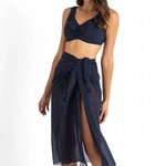 Model wearing Cosmopolitan Classic Mesh Sarong Ink by Jantzen, available at The Foundation, styled as a lightweight midi wrap over swimwear.