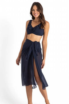 Model wearing Cosmopolitan Classic Mesh Sarong Ink by Jantzen, available at The Foundation, styled as a lightweight midi wrap over swimwear.