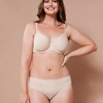Smiling model in Virginia Spacer Bra in Skin tone from The Foundation, featuring smooth cups, breathable spacer fabric, and a supportive fit.