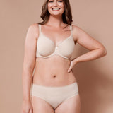 Smiling model in Virginia Spacer Bra in Skin tone from The Foundation, featuring smooth cups, breathable spacer fabric, and a supportive fit.