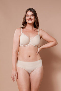 Smiling model in Virginia Spacer Bra in Skin tone from The Foundation, featuring smooth cups, breathable spacer fabric, and a supportive fit.
