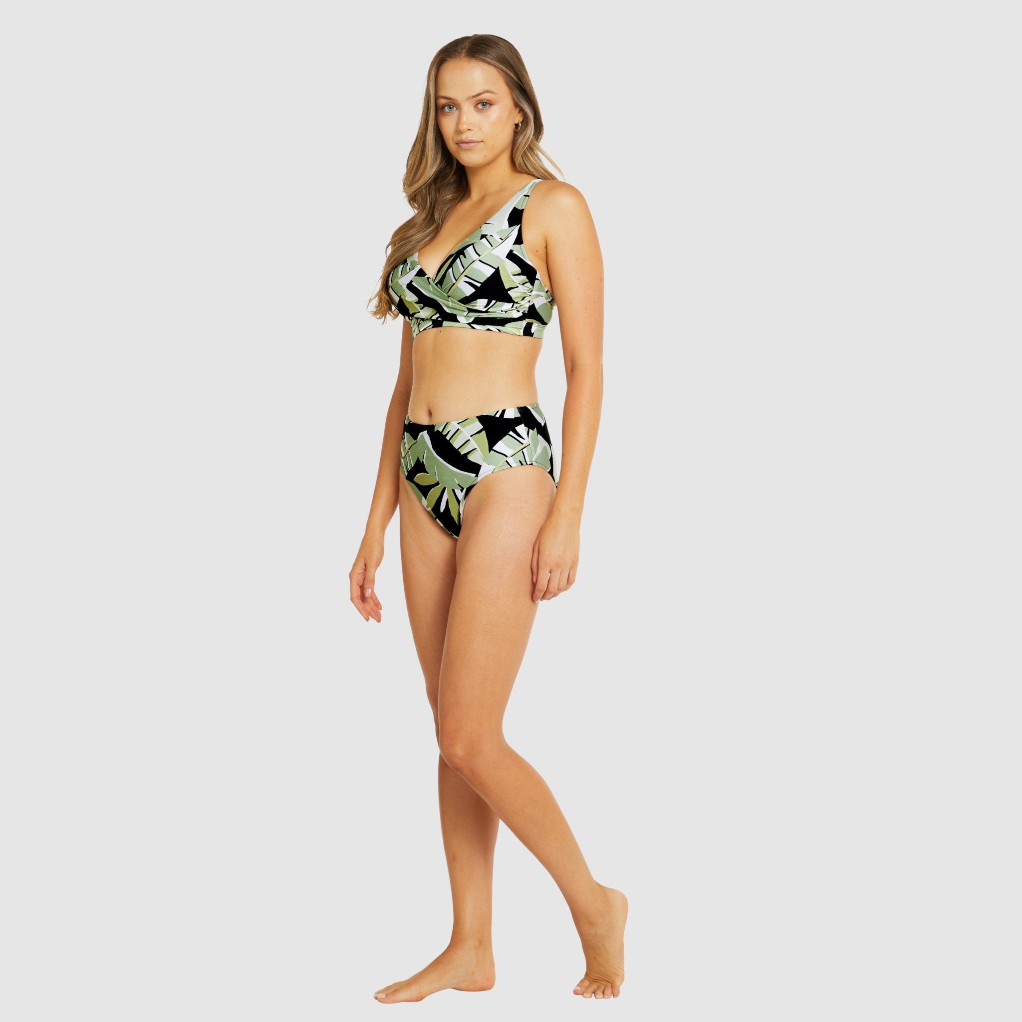 Model wearing Baku Canary Islands Mid Bikini Pant in black botanical print with matching supportive bikini top.