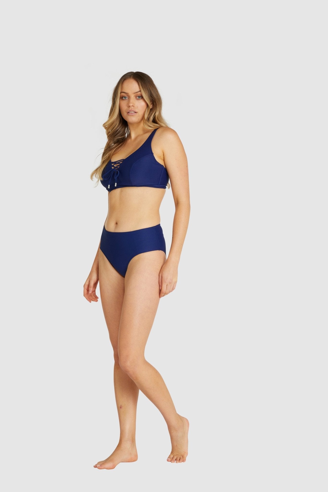 Side angle of navy blue Rococco bikini top featuring lace-up detail and wide straps.