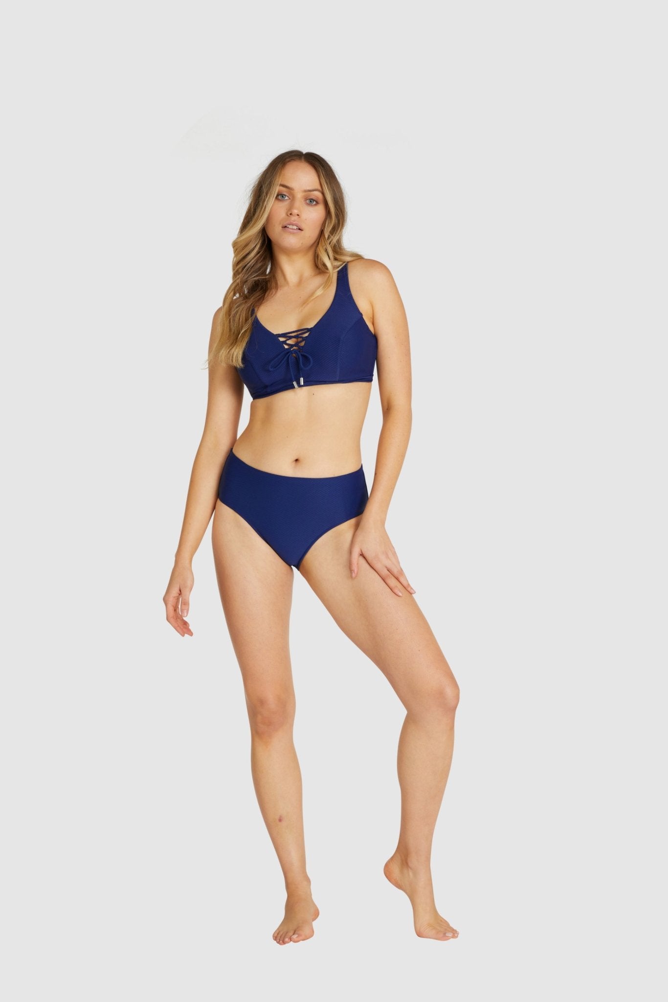 Model standing front-on in Baku Rococco Admiral bikini set, highlighting lace-up detail and structure.