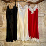 Kathryn Silk Chemise shown in rouge, black, and ivory colours hanging side by side.