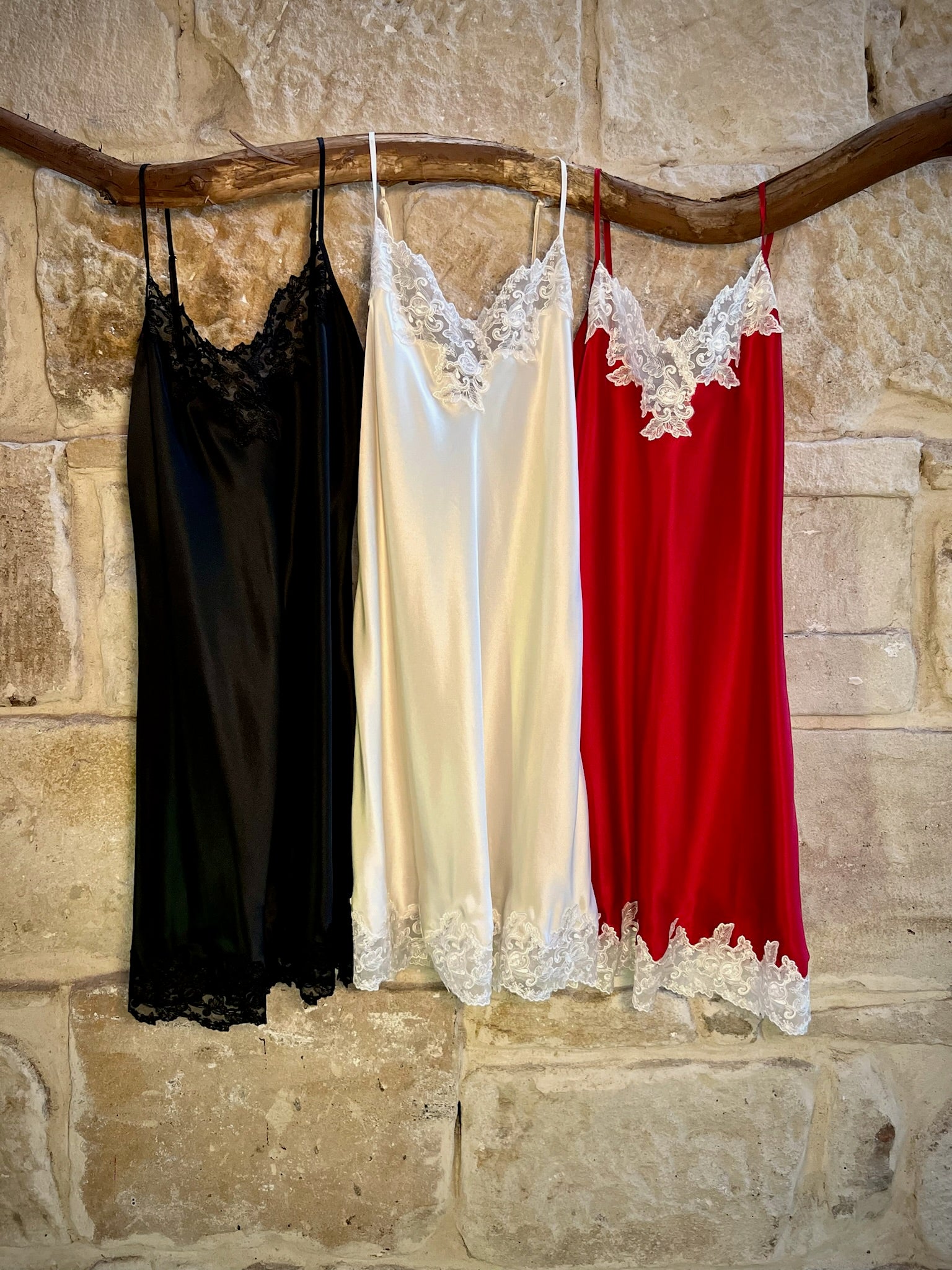 Kathryn Silk Chemise shown in rouge, black, and ivory colours hanging side by side.