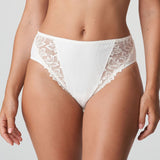 Model wearing PrimaDonna Deauville Full Brief in Natural from The Foundation, with high waist coverage and floral embroidery at the hips. front view