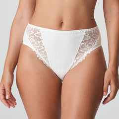 Model wearing PrimaDonna Deauville Full Brief in Natural from The Foundation, with high waist coverage and floral embroidery at the hips. front view