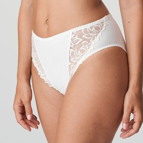Model wearing PrimaDonna Deauville Full Brief in Natural from The Foundation, with high waist coverage and floral embroidery at the hips. side view