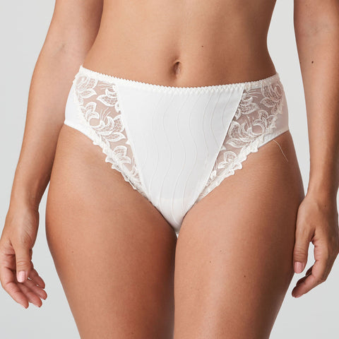 Model wearing PrimaDonna Deauville Full Brief in Natural from The Foundation, with high waist coverage and floral embroidery at the hips. front view