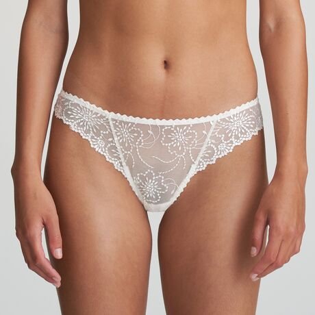 Model wearing Marie Jo Jane Thong Brief in Natural from The Foundation, with floral embroidery, sheer lace, and pearl-detailed bows at the back. FRONT VIEW