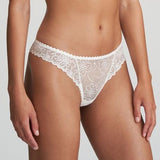 Model wearing Marie Jo Jane Thong Brief in Natural from The Foundation, with floral embroidery, sheer lace, and pearl-detailed bows at the back. SIDE VIEW
