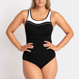 Woman modeling the black POOLPROOF mastectomy scoop one-piece swimsuit with white piping and side gathers.