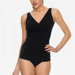 Model wearing the POOLPROOF Sheath black one-piece swimsuit with crossover neckline and wide straps.