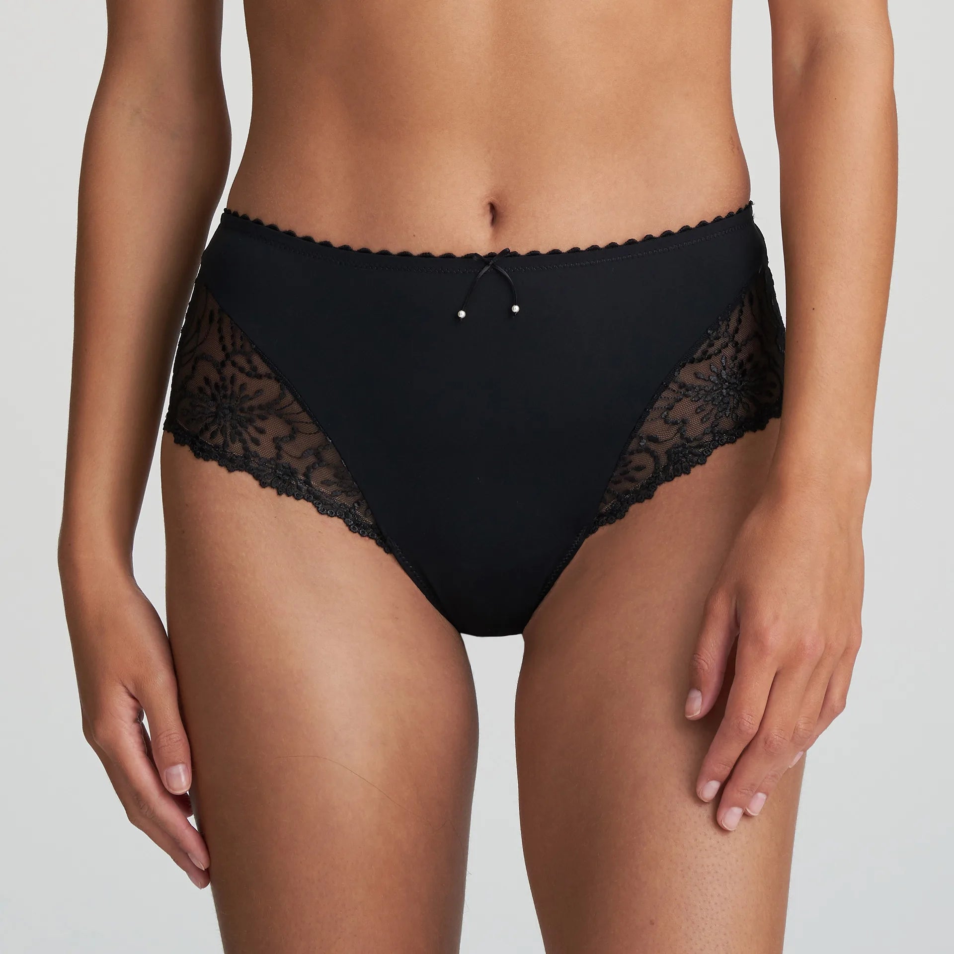Model in Marie Jo Jane Full Brief in Black from The Foundation, featuring full coverage, sheer floral embroidery, and a front bow with pearl detail. front view