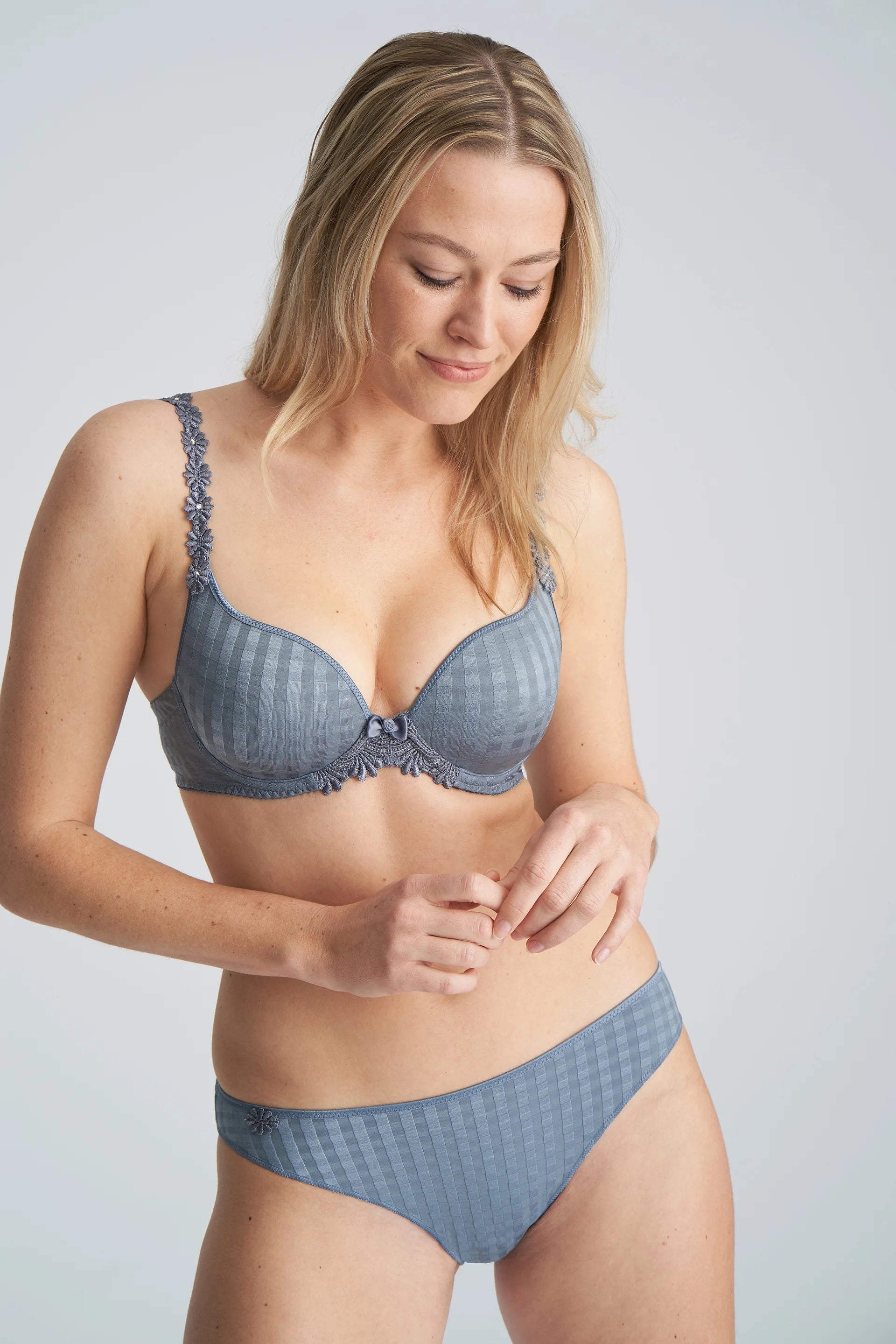 Three-quarter view of model wearing the Avero bra in Atlantic Blue, highlighting supportive plunge cups and soft sheen fabric.
