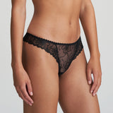 Model wearing Marie Jo Jane Thong Brief in Natural from The Foundation, with floral embroidery, sheer lace, and pearl-detailed bows at the back. side view