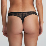 Model wearing Marie Jo Jane Thong Brief in Natural from The Foundation, with floral embroidery, sheer lace, and pearl-detailed bows at the back. back view