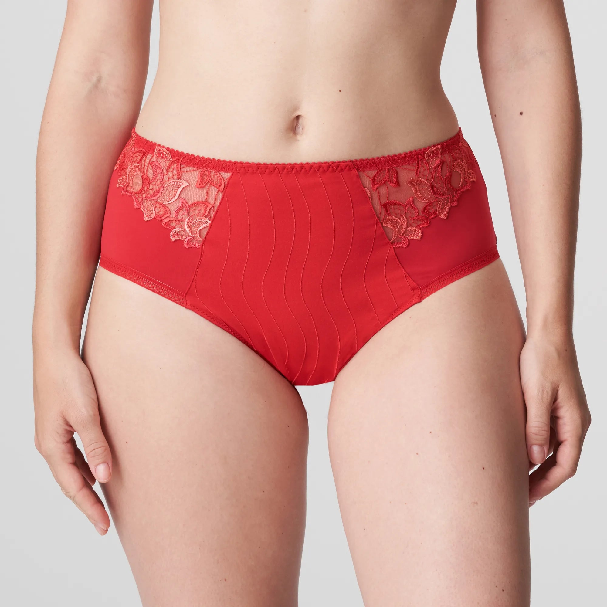 Model wearing PrimaDonna Deauville Full Brief in Scarlet from The Foundation, featuring high waist fit, smoothing support, and lace detail at the hips. close up
