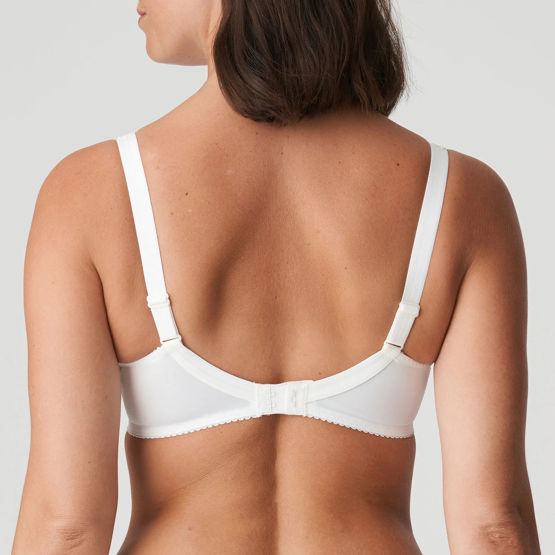 Model wearing PrimaDonna Deauville Full Cup Bra in Natural from The Foundation, featuring deep supportive cups and elegant embroidered detailing. back view