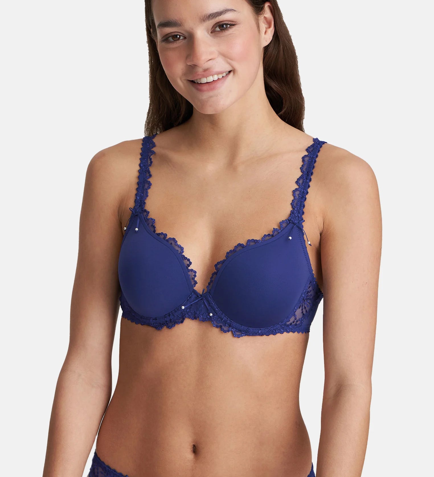 Model wearing Marie Jo Jane Padded Heart Shape Bra in Lazurite Blue from The Foundation, with embroidered cups, plunge neckline, and convertible straps. 