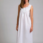 Model wearing Sleeveless Pleated With Yoke Nightie in white, featuring a v-neckline with lace and ribbon trim, and a buttoned pleated yoke.