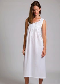 Model wearing Sleeveless Pleated With Yoke Nightie in white, featuring a v-neckline with lace and ribbon trim, and a buttoned pleated yoke.