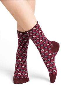 Model wearing Cotton Optical Dots Socks Mid Chianti by Bleuforêt, available at The Foundation, featuring red geometric dot patterned socks for women.